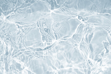 Water waves surface hits the sunlight. Close up swimming pool water background. Transparent water...