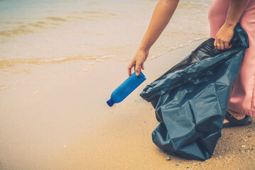 Woman are collecting garbage on the beach. 