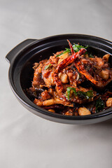 local cook live fresh catfish meat with spicy red dry chili asam sauce in big black claypot on wood table asian Chinese banquet halal seafood steamboat menu 