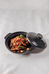 local cook live fresh catfish meat with spicy red dry chili asam sauce in big black claypot on wood table asian Chinese banquet halal seafood steamboat menu 