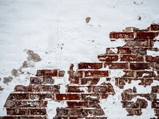 A red brick wall with peeling paint.