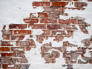 A red brick wall with peeling paint.