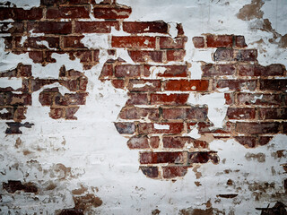 A red brick wall with peeling paint.