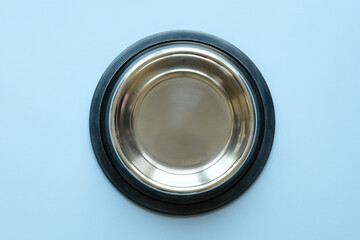 The empty pet's metal bowl on a blue  background top view