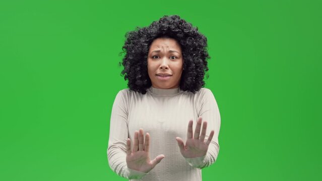 portrait african american woman frightened and panicked puts his hands forward in the desire to defend herself Isolated on Green Screen