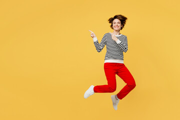 Fototapeta na wymiar Full body fun young woman wear casual black and white shirt jump high point index finger aside indicate on workspace area copy space mock up isolated on plain yellow color background studio portrait.
