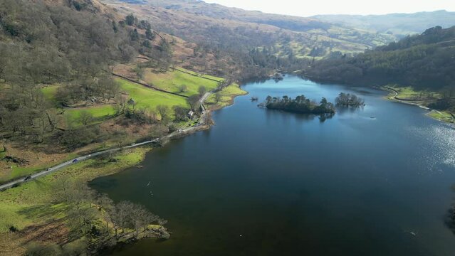 Pan across Rydal Water with busy road in the English Lake District Cumbria