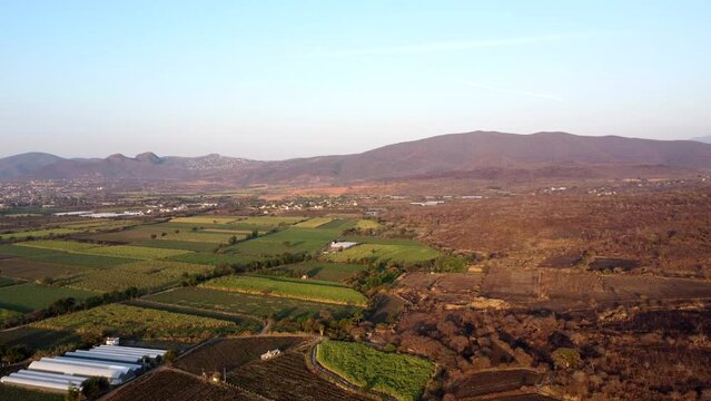 aerial view of farmland and mountains at sunrise