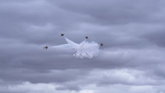 KAI T-50B Fighter Planes With Trails Of Smoke During Aerial Performance Against Cloudy Sky. wide
