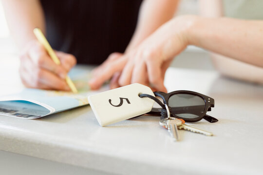 Hotel guest receiving room key at reception desk