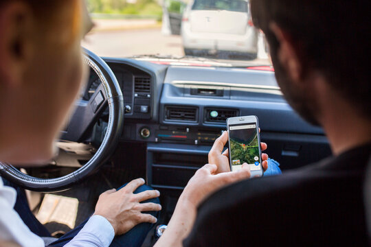 Friends using smart phone to navigate car