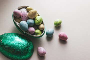 Ester egg filled with Easter sweets in green, blue, yellow and pink