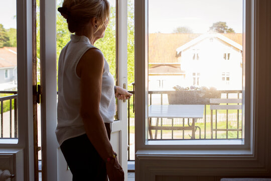 Woman opening balcony door