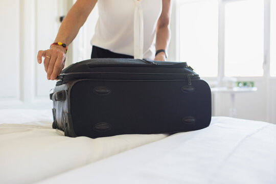 Midsection of woman packing suitcase