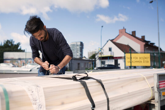 Man securing wood paneling package with tape
