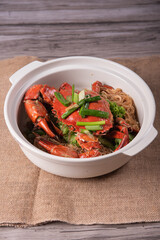 local wok fried Sri Lanka big fresh live crab with spicy onion garlic chilli salted egg yolk white pepper sauce vermicelli on wood table asian chinese halal food banquet seafood menu for restaurant