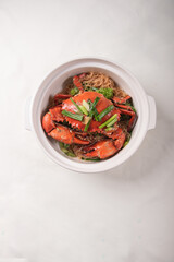 local wok fried Sri Lanka big fresh live crab with spicy onion garlic chilli salted egg yolk white pepper sauce vermicelli on wood table asian chinese halal food banquet seafood menu for restaurant