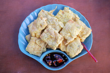 Tempe Mendoan is a traditional food made from tempeh which is smeared with flour dough mixed with sliced ​​green onions and spices, and cooked by frying. served with soy sauce and chili chunks