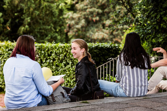 Students sitting outside library during study session.