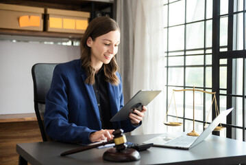Asian lawyer woman working with a laptop and tablet in a law office. Legal and legal service...