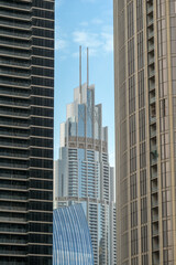 Fototapeta na wymiar Futuristic and modern commercial and residential highrise tower skyscraper architecture with glass facades and clean lines in downtown Dubai, United Arab Emirates for millionaires and high society