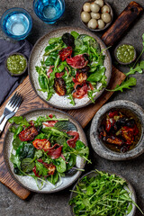 Salad with arugula, spinach, dried tomato and ham serrano paleta iberica. Low carbs keto recipe