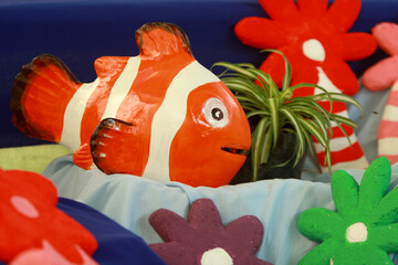 an orange fish-shaped statue made of clay