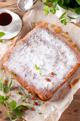 Traditional apple pie on a white plate on a wooden table. Charlotte pie on a platter. Delicious homemade pastry on the table. Top view