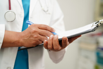 Doctor checking and note diagnosis medicine in clipboard of patients in hospital.