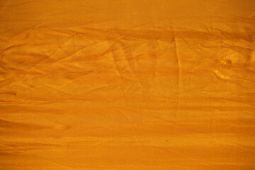 Close up of the uneven folded texture on the orange colour saree