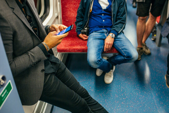 Man commuting by subway using smart phone
