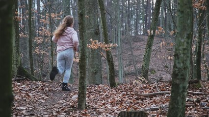 Young Caucasian Girl Running Away from Unknown Danger Through Autumn Forest