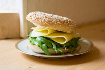 Delicious vegetarian sandwich on bagel bread. A bagel is a bread traditionally made from wheat flour and usually has a hole in the center.