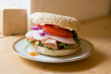 Delicious turkey sandwich on bagel bread. A bagel is a bread traditionally made from wheat flour and usually has a hole in the center.