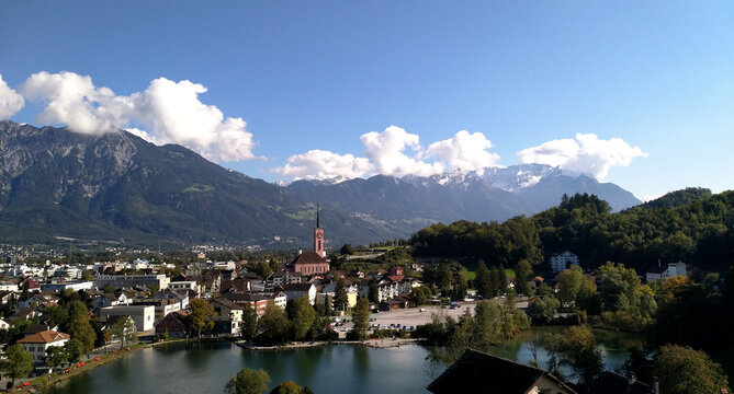 overlooking a lake and a small village in switzerland with the alps in background