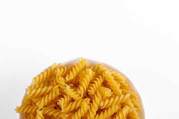 Pasta products in the form of a spiral on a plate, texture, on a white background