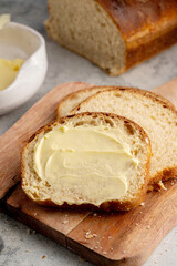 Closeup sourdough slice of homemade white loaf bread with butter. 