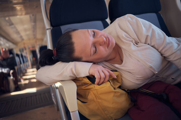 Woman sleeping in a train seat while travelling.