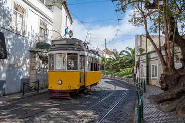 Naklejka na ściany i meble Retro yellow tram on street in Lisbon, Portugal