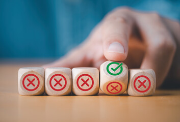 Hand flipping wooden cube block to change red cross mark to correct tick sin symbol for reject and...