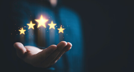 Businessman holding five glowing golden stars for excellent evaluation survey after client use...