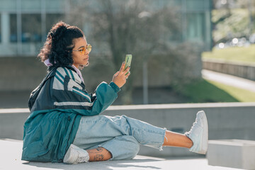 girl on the street sitting with mobile phone or smartphone