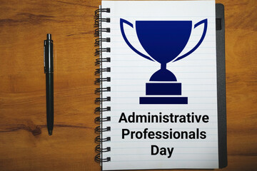 Administrative Professionals Day background with text and trophy on notebook with pen. Template for background, banner, card, poster with text inscription