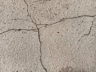 The surface of the old cement floor has holes and various cracks.