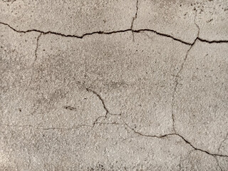 The surface of the old cement floor has holes and various cracks.