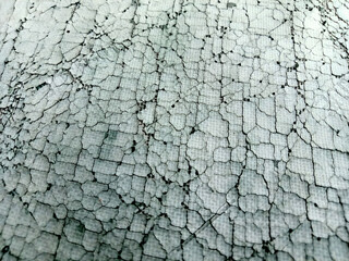 Synthetic rubber fabric surface has many cracks, light blue color.