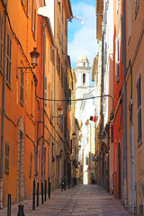 Fototapeta na wymiar typical alley with houses with red and orange walls in the old town of Bastia, on the island of Corsica, nicknamed the Island of Beauty