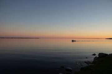 Naklejka premium Little boat in the sunset over the lake