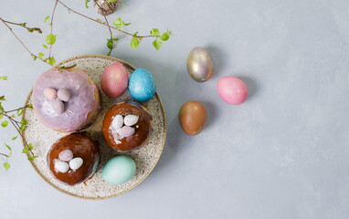 Easter background. Cakes, painted eggs, birch twigs on a light background