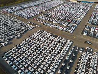 Aerial top view of new cars parking for sale stock lot row, dealer inventory import and export business commercial worldwide, Automobile and automotive industry distribution logistic global transport